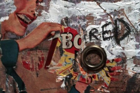 Detail of a sculptural collage combining a woman from an advertisement, torn layers and a round metal object.