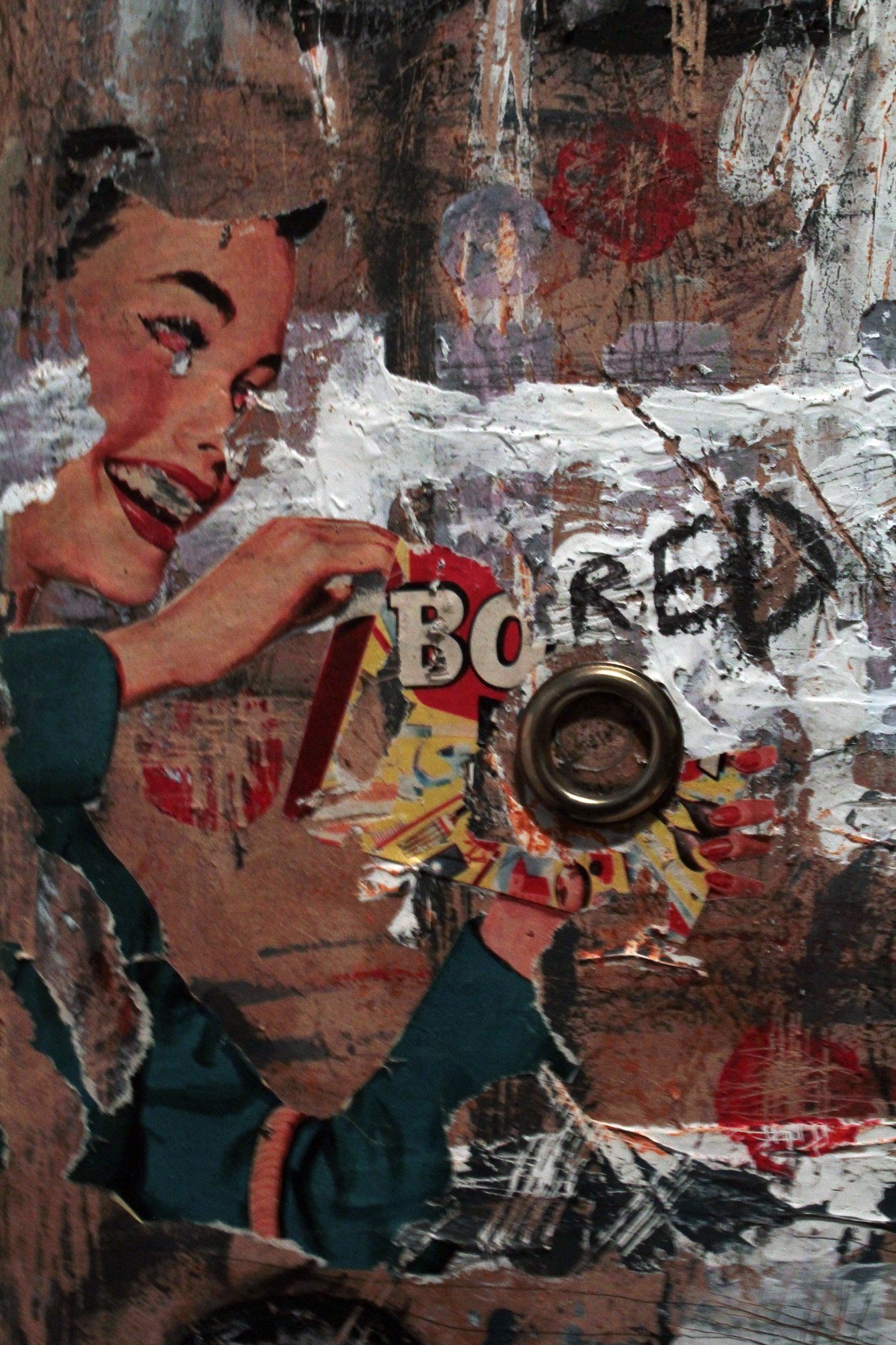 Detail of a sculptural collage combining a woman from an advertisement, torn layers and a round metal object.