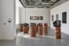 Gallery installation with CRT televisions on brick plinths and artworks on the walls